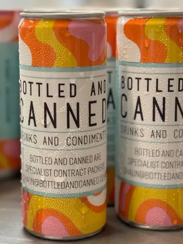 Condensation-covered cans with colorful retro patterns labeled Bottled and Canned drinks and condiments.